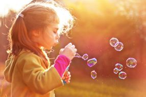 Фотообои Девочка играет с мыльными пузырями